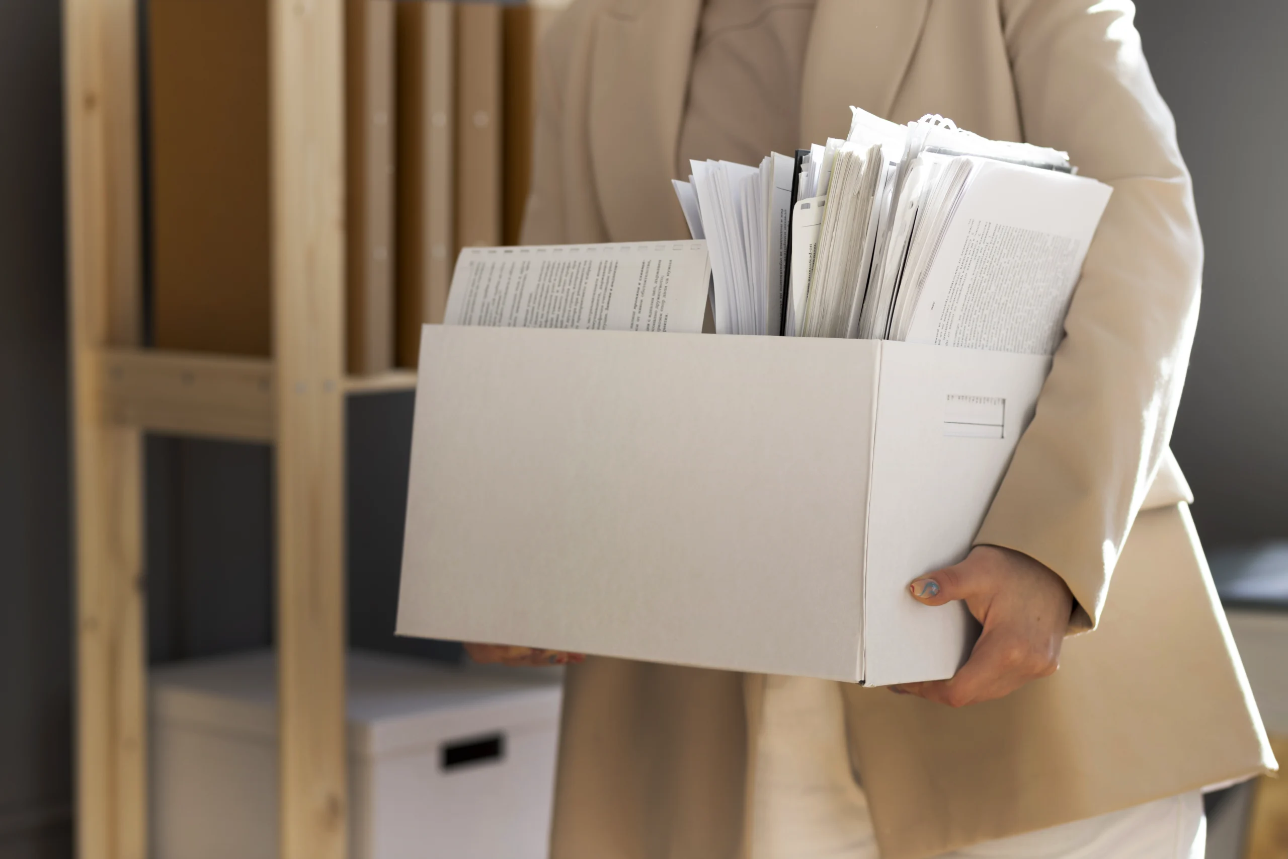 Persona che trasporta una scatola con numerosi documenti, rappresentazione della preparazione per la domanda di permesso per conviventi